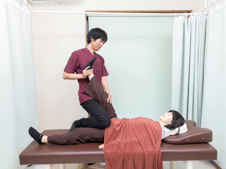 ハムストリングスのストレッチを受けている女性