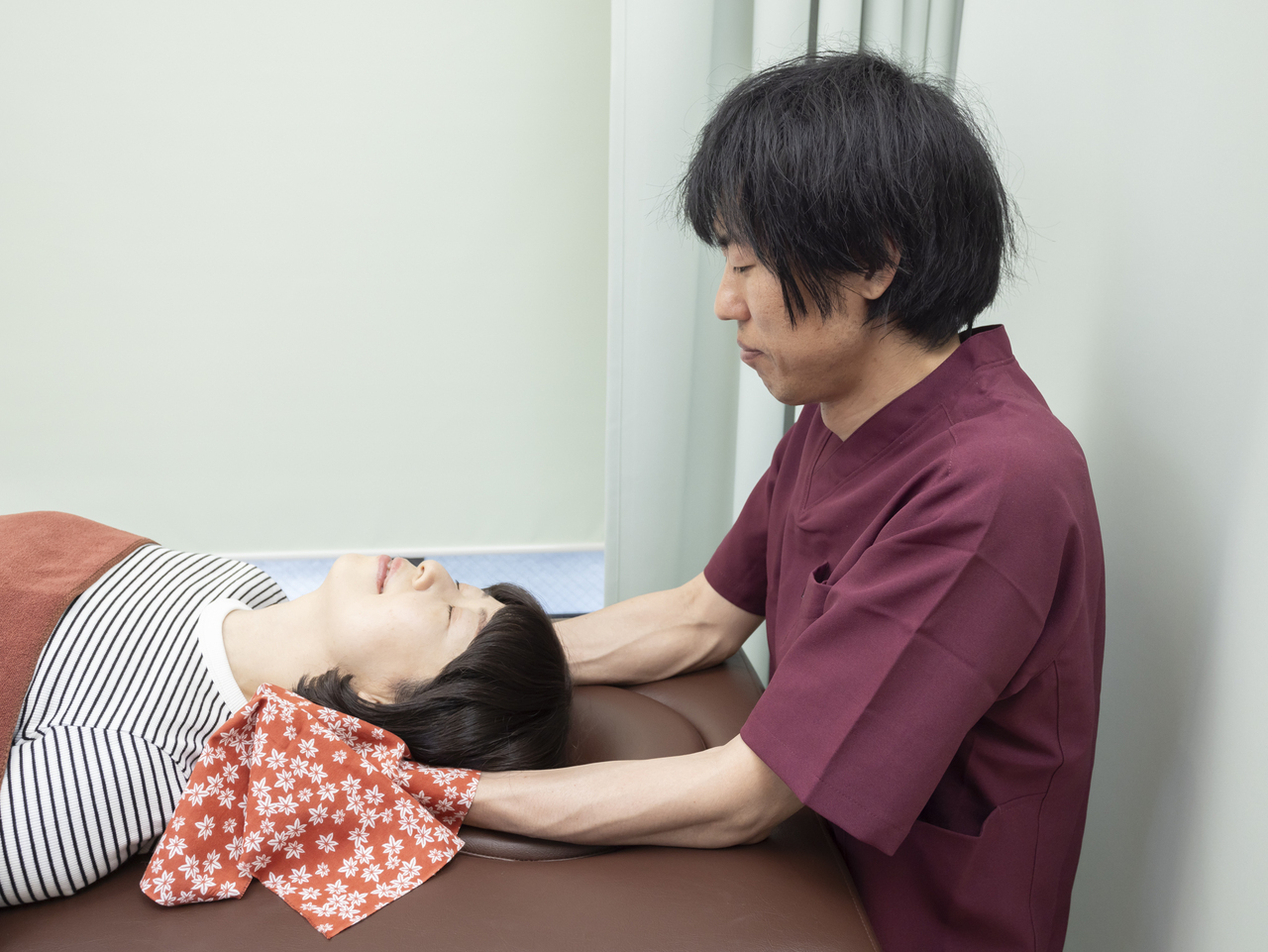 女性の首をマッサージしている男性