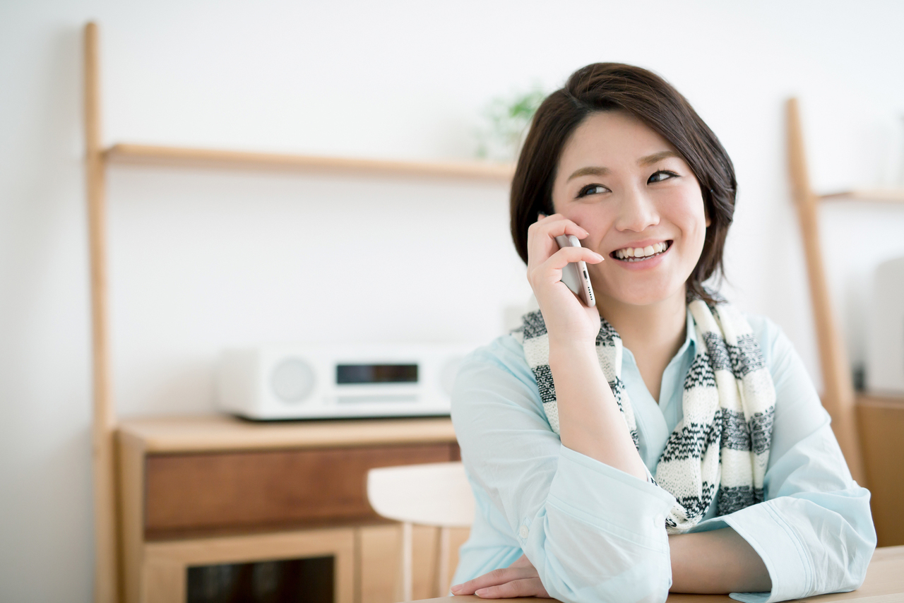 電話をしながら微笑む女性