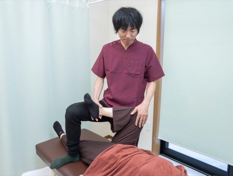 股関節のストレッチを受けている女性